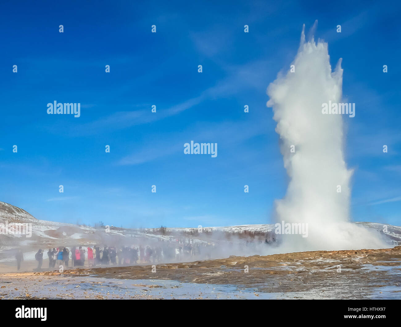 Menge beobachten Ausbruch eines Geiser, oder heiße Quelle, wie es seine volle Höhe erreicht, Golden Circle, Island Stockfoto