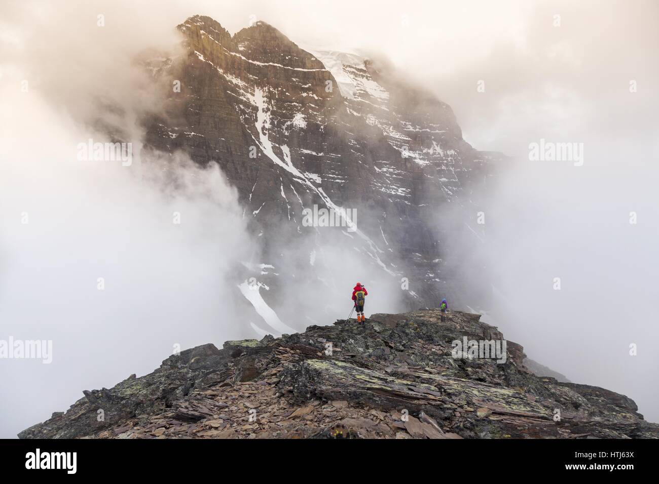 Isolierte Wanderer Silhouette und Mount Temple versteckt von Wolken auf Skyline. Alpine Landscape Bergsteigen im Banff National Park, Canadian Rockies Stockfoto