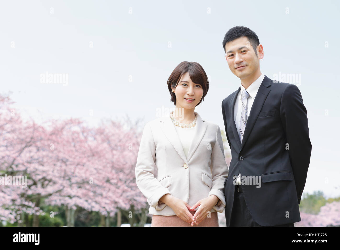 Japanisches Paar mit Kirschblüten in einem Stadtpark Stockfoto