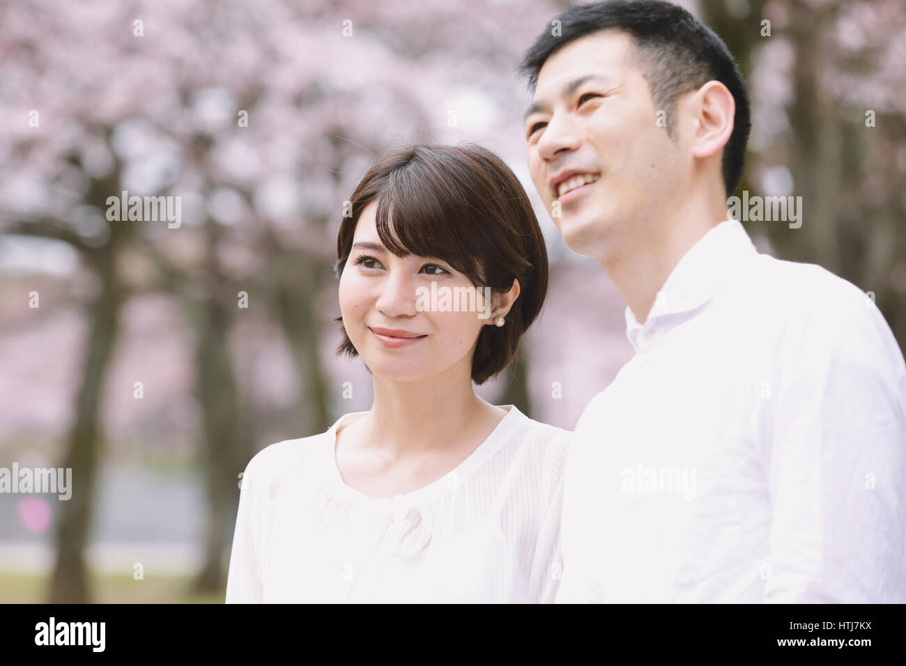 Japanisches Paar mit Kirschblüten in einem Stadtpark Stockfoto