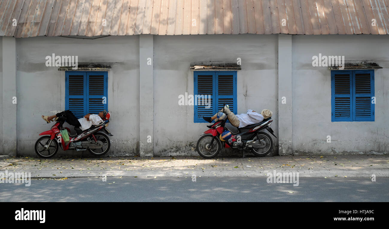 HO-CHI-Minh-Stadt, VIET NAM-APRIL 30, 2016: Vietnamesische Motorrad Taxi Fahrer Zirkus beim Schlafen auf Motorrad in gefährliche am Bürgersteig, set Mann moto Stockfoto