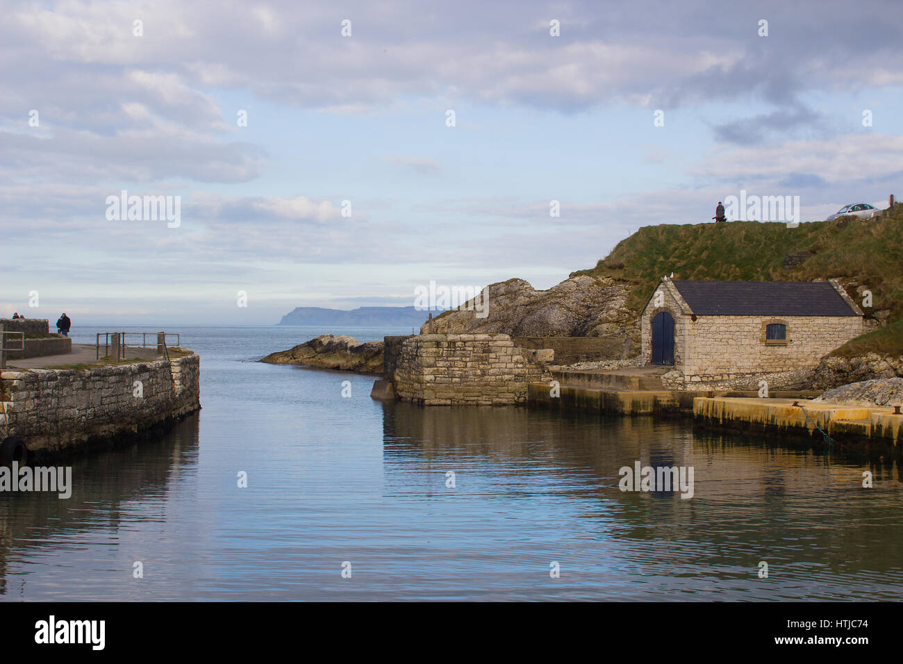 Der kleine Hafen von Ballintoy auf der North Antrim Küste Nordirlands mit seinen Stein gebaut Bootshaus im Meer reflektieren Stockfoto