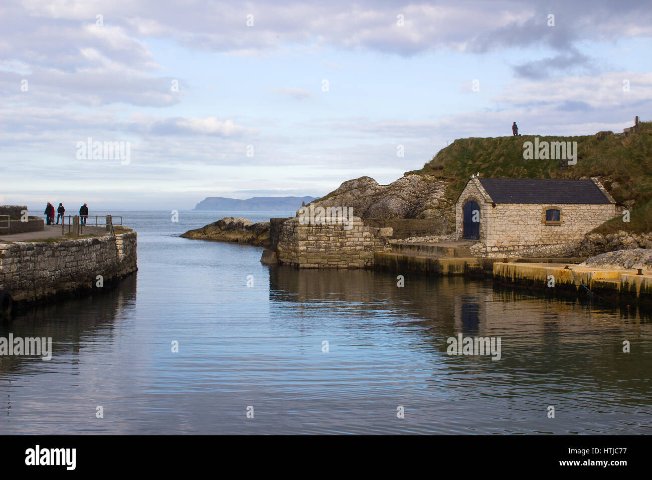 Der kleine Hafen von Ballintoy auf der North Antrim Küste Nordirlands mit seinen Stein gebaut Bootshaus im Meer reflektieren Stockfoto