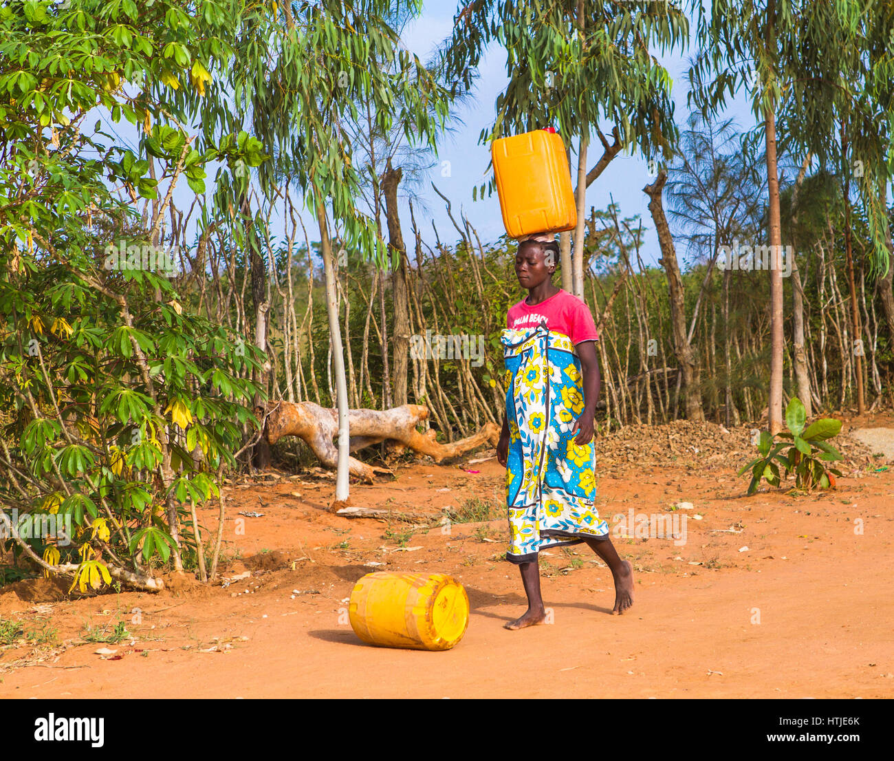 Eine junge Frau trägt Wasser vom nächstgelegenen Hydranten zu ihr nach Hause. Malindi, Kenia. Stockfoto