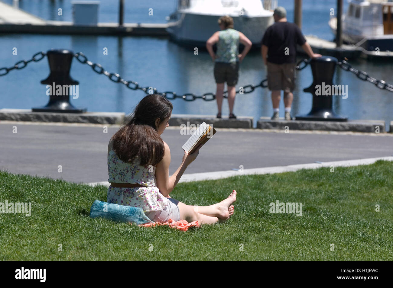 Ein Mädchen lesen und Fischerhafen in Bostons Christopher Columbus Park in der Stadt North End Stockfoto