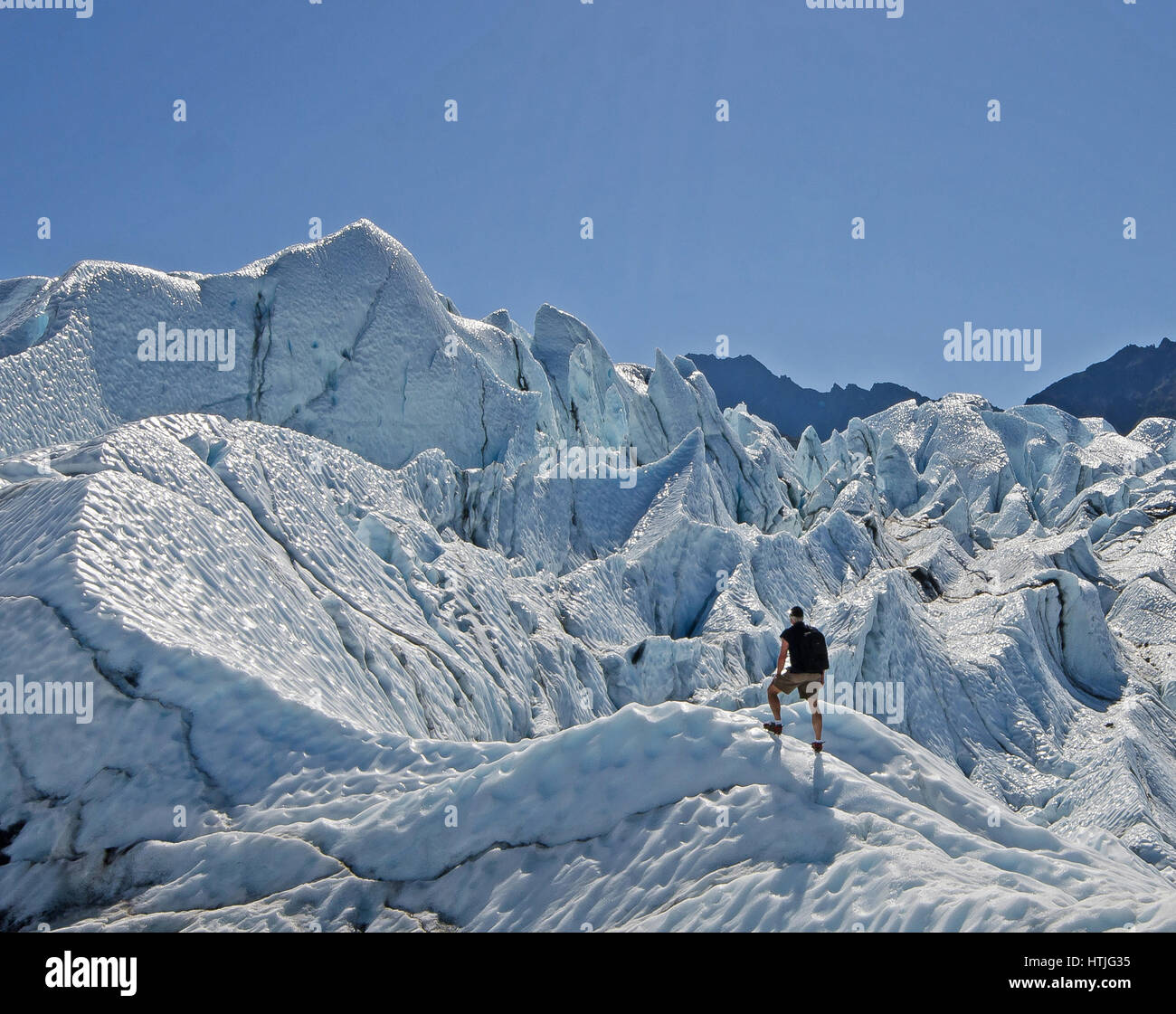 Eine Person treks auf Matanuska Gletscher an einem sonnigen Tag Stockfoto