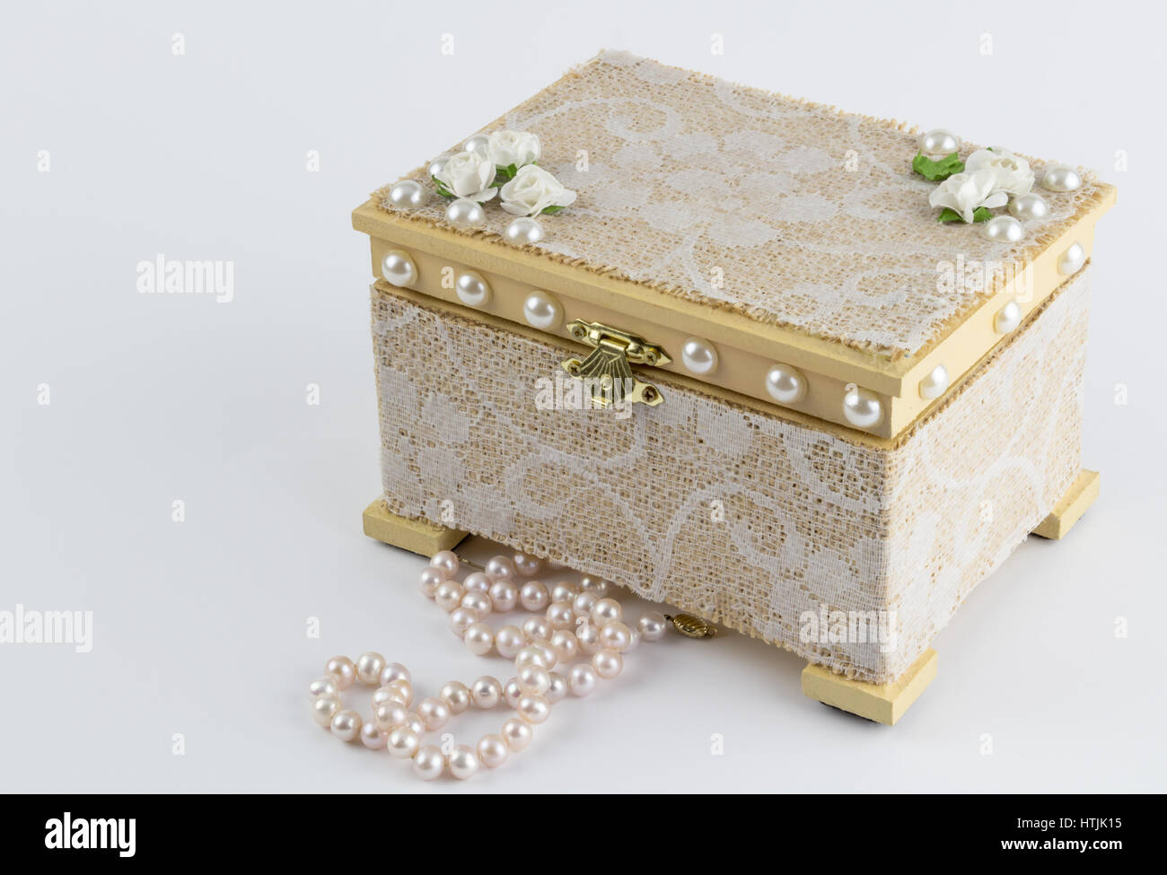 Holz-Box mit rosa Perlenkette auf weiß Stockfoto