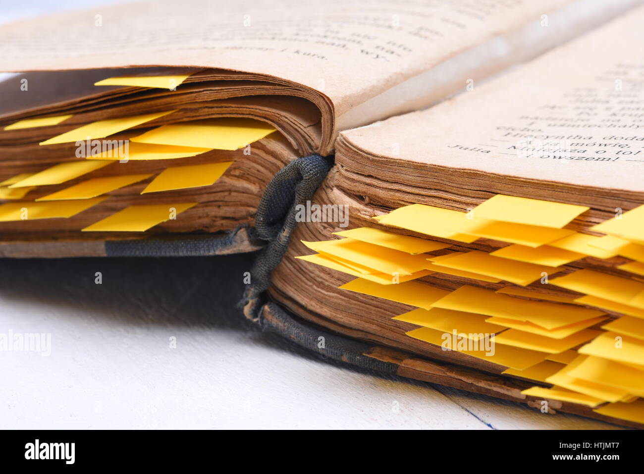 Alte offenes Buch mit Papier Lesezeichen auf Schreibtisch Nahaufnahme Stockfoto