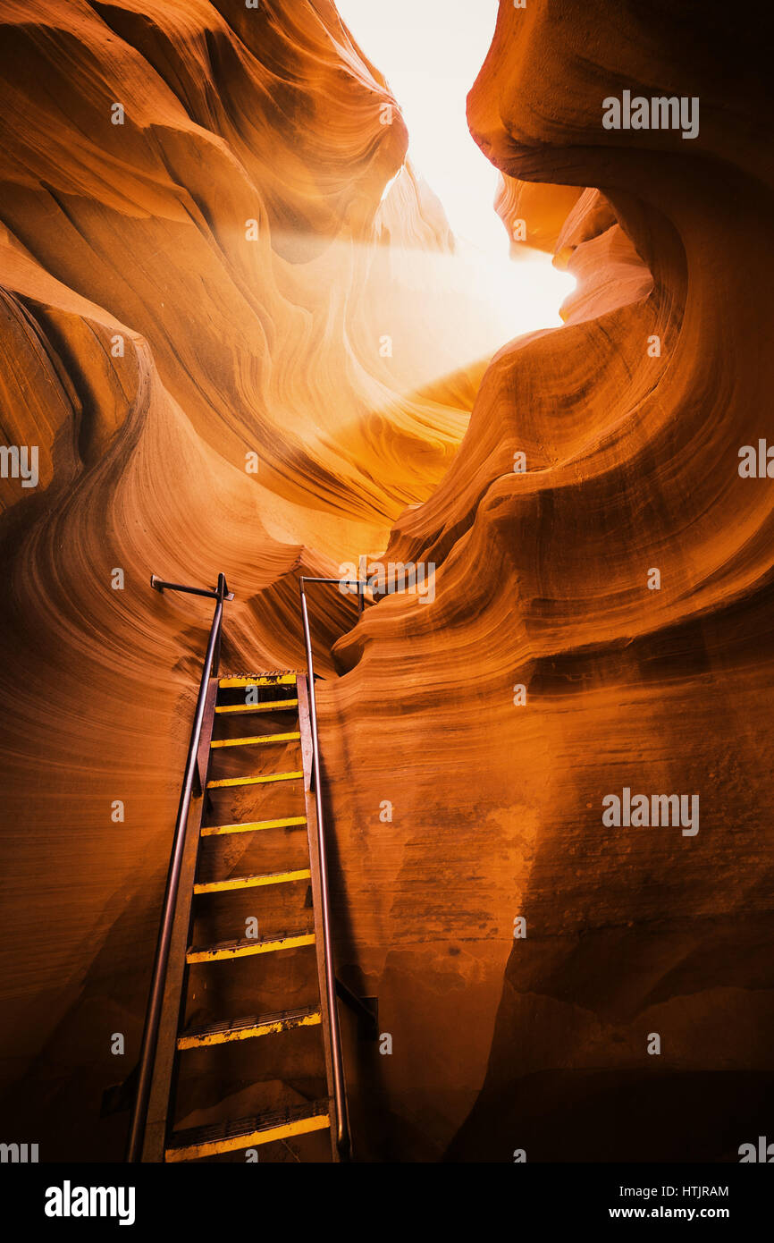 Schöne Aussicht auf erstaunliche Sandstein-Formationen mit einer Leiter, die gegen eine magische Lichtstrahl in berühmten Antelope Canyon in der Nähe von Page, Arizona, USA Stockfoto