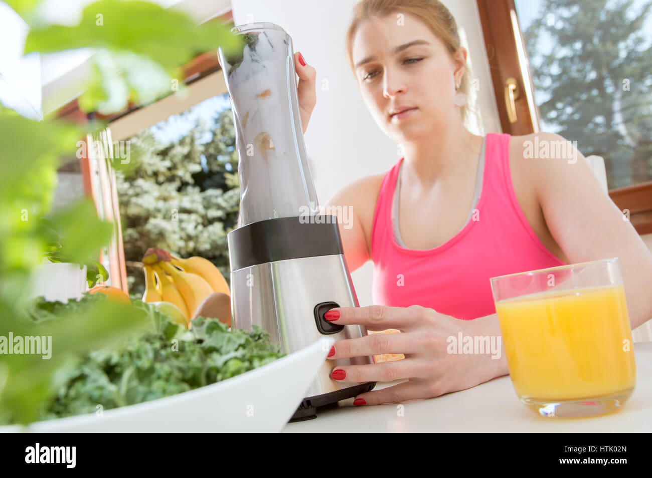 Sportliche Frau bereitet einen frisches Obst-smoothie Stockfoto