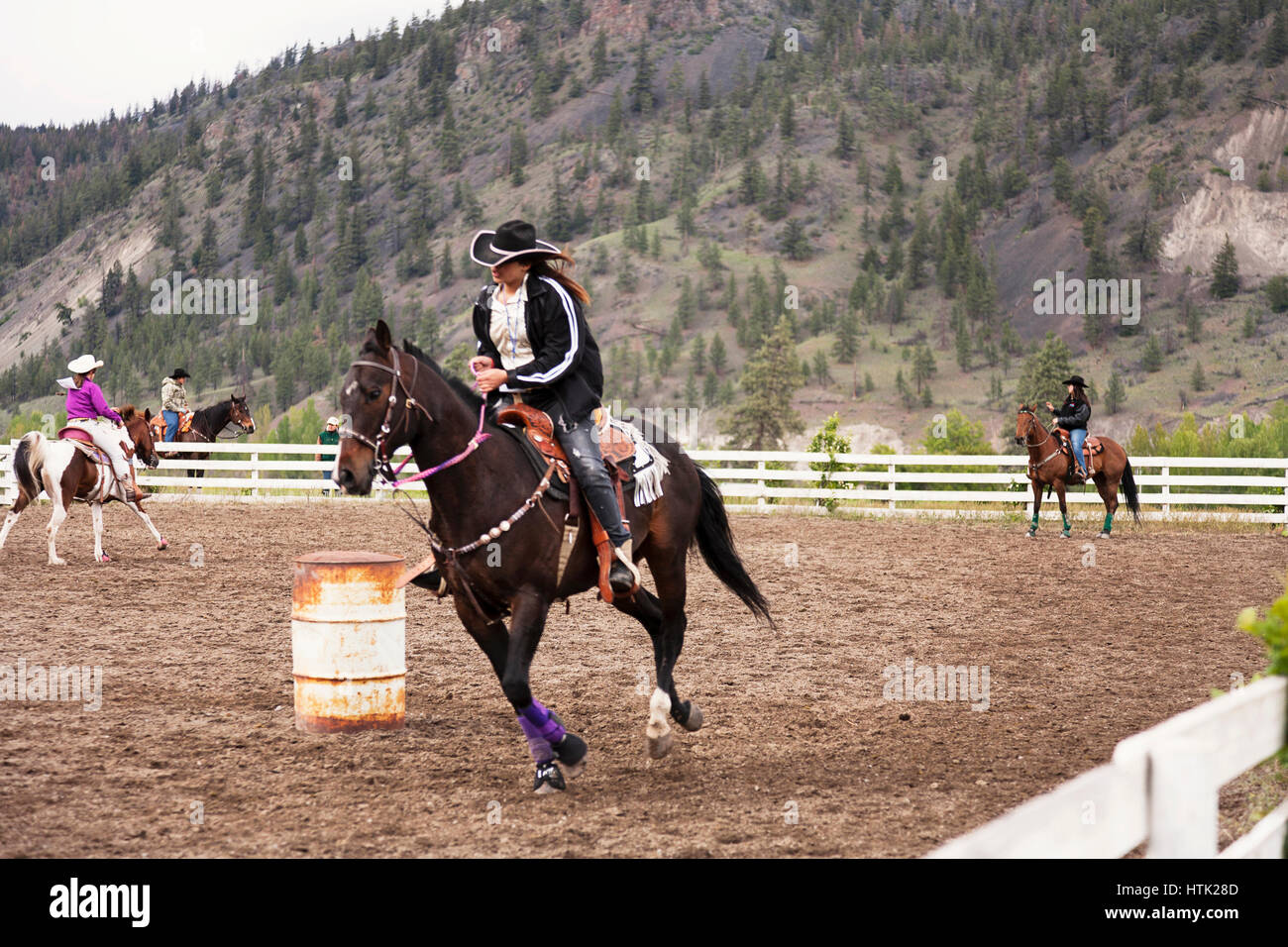 Cowgirls Faßlaufen am reichsten indischen Rodeo üben. Merritt, BC, Kanada Stockfoto