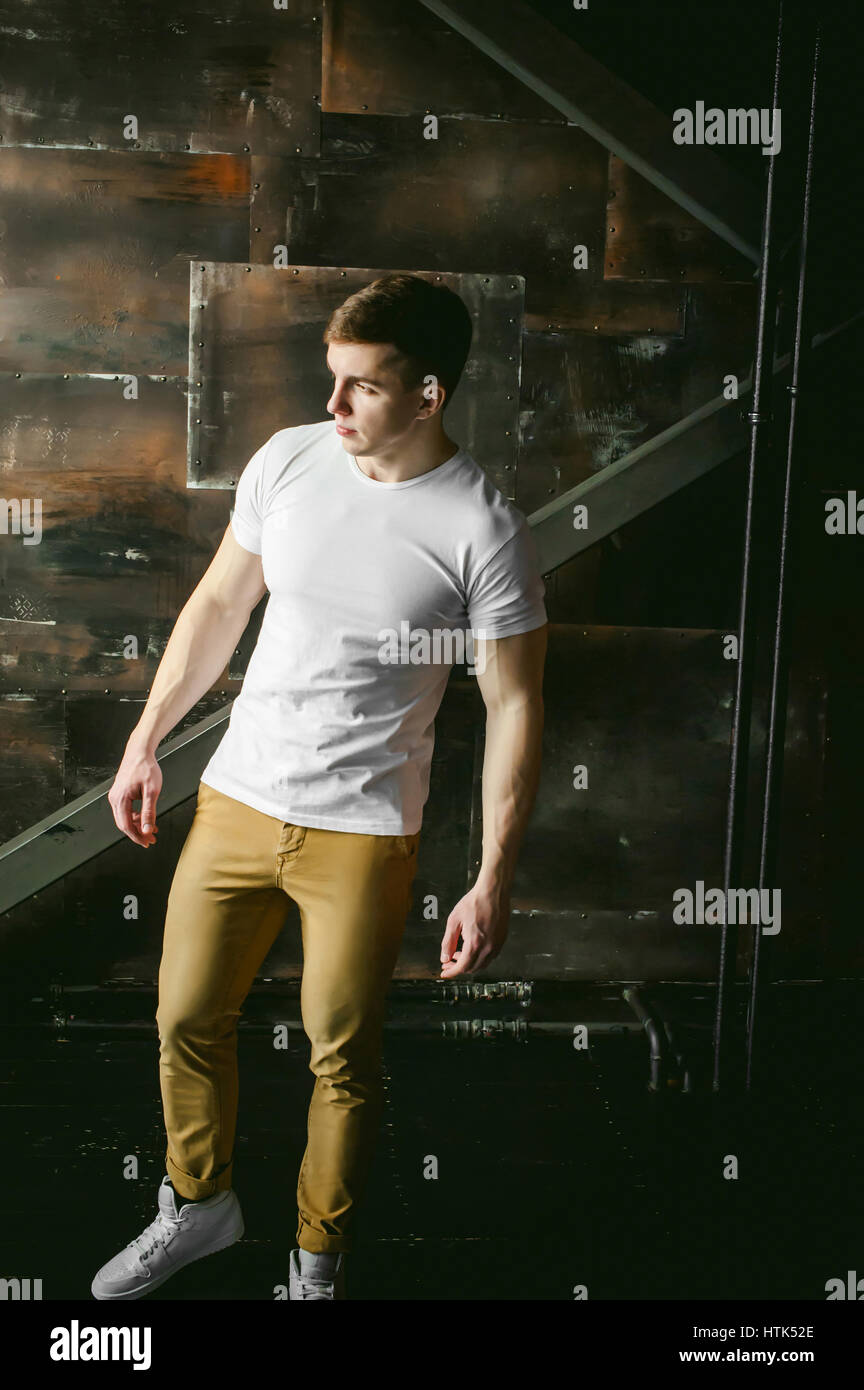 Junge sexy Männer Bodybuilder Athlet, Studioportrait in einem Loft auf dem  Hintergrund einer stilisierten Metall Wand, ein Kerl-Modell in ein weißes  T-shirt und eine braune tro Stockfotografie - Alamy