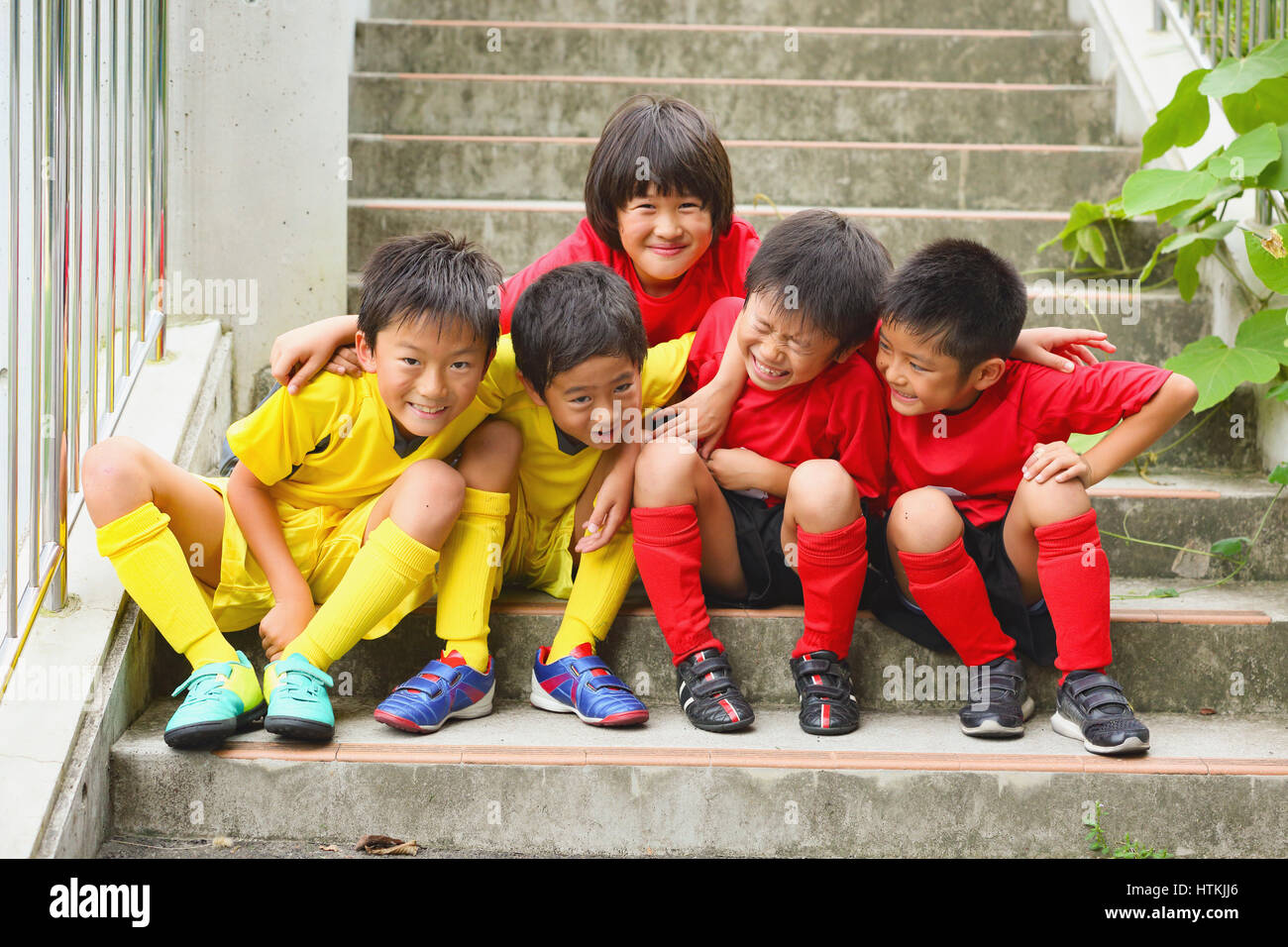 Japanische Kinder im Fußball uniform auf einer Treppe Stockfoto