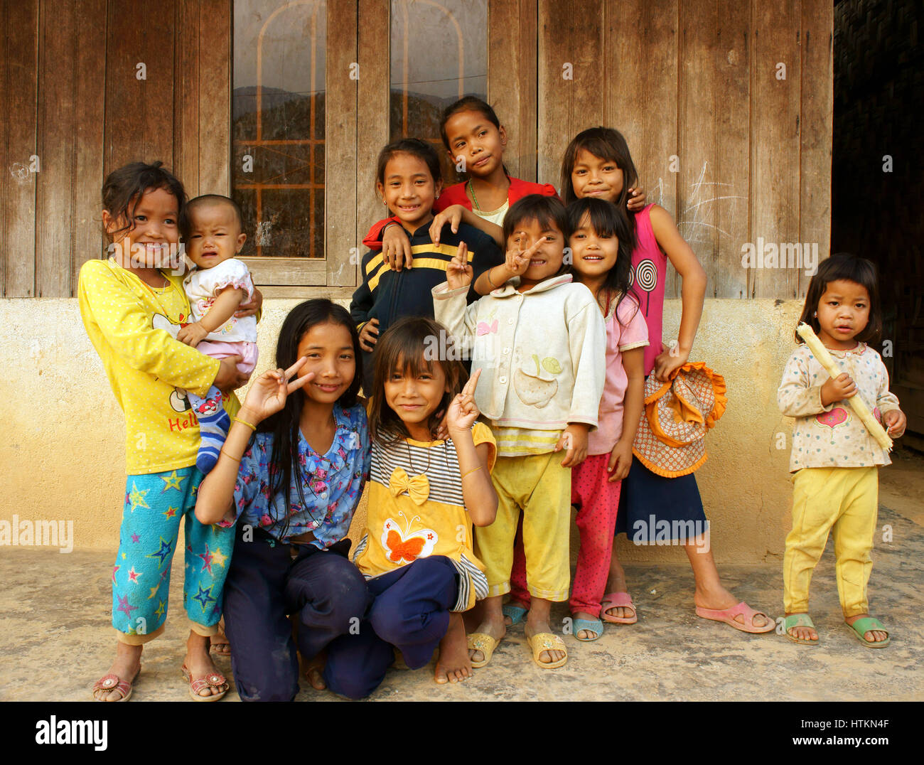 DAKLAK, VIET NAM, asiatische Kinder Stand, posiert auf Holzhaus von