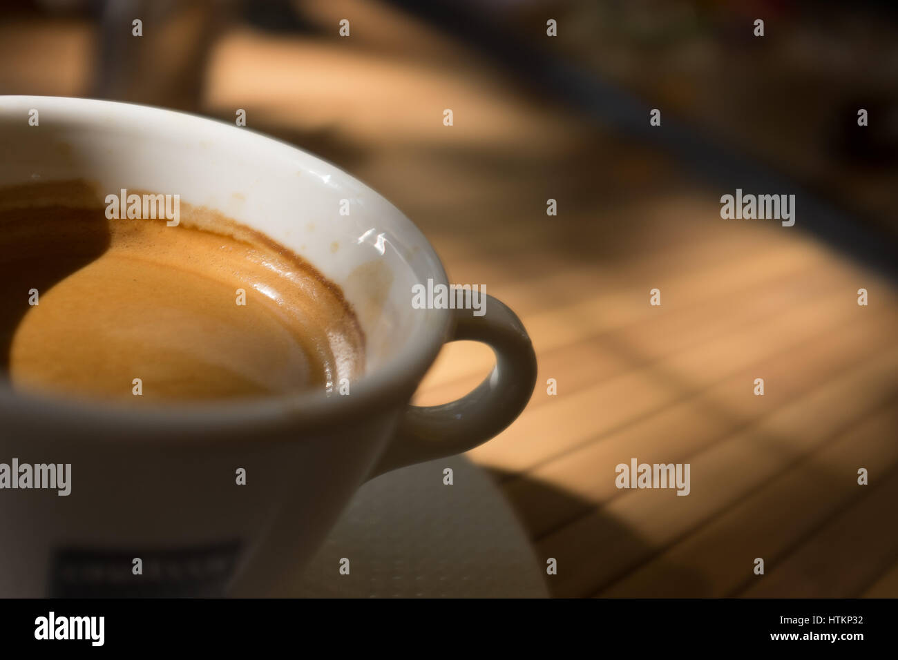 Kaffeetasse in gefleckte Sonnenlicht auf Tisch Stockfoto