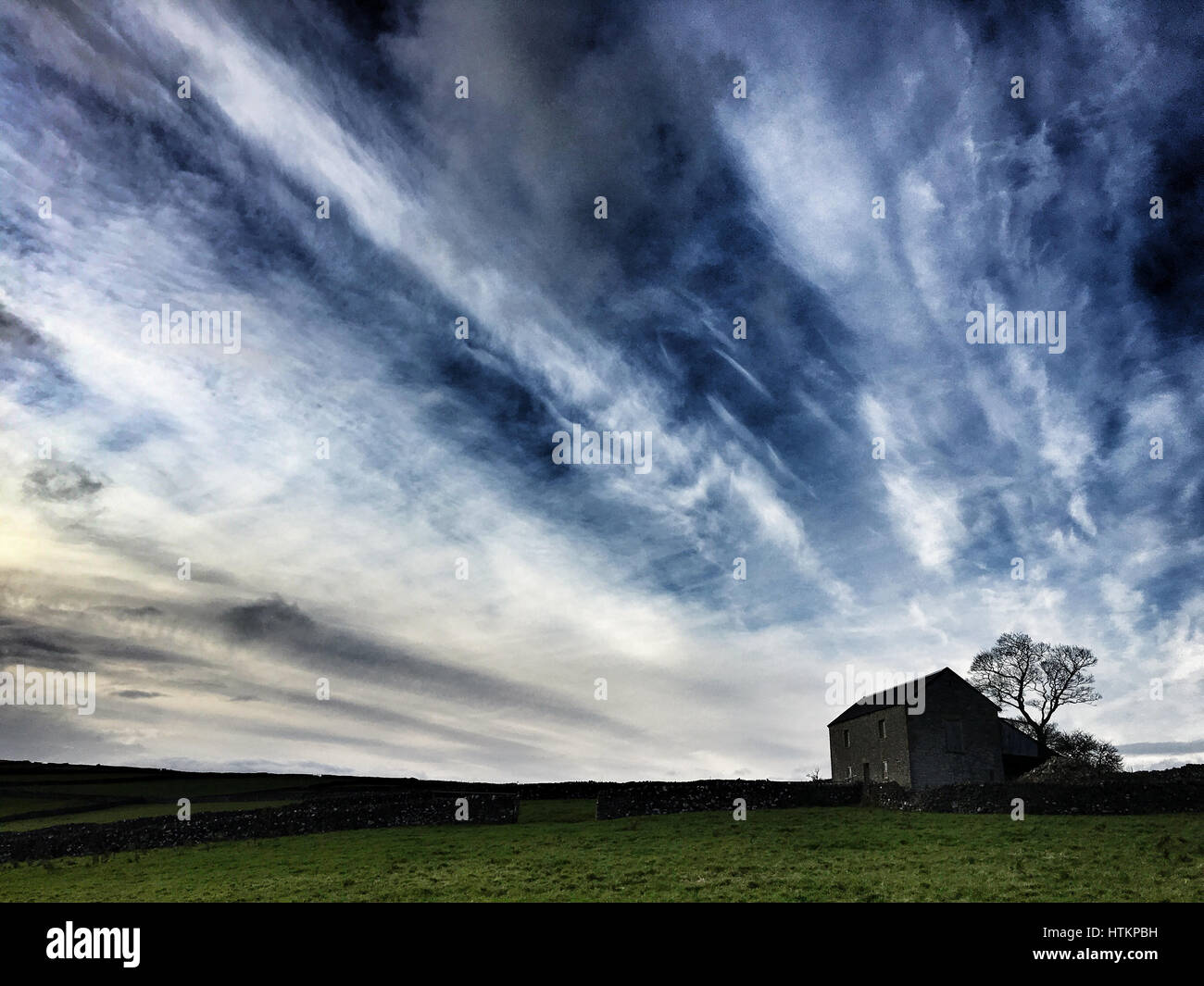 Isoliertes Haus in ländlicher Umgebung vor einem großen dramatischen Himmel Stockfoto