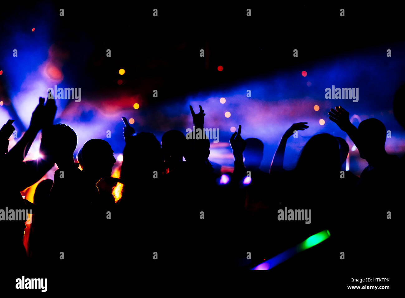 Große Gruppe von Menschen auf der Tanzfläche. Es ist eine sehr Vivd bunte Hintergrundbeleuchtung. Echte Menschen. Echte tanzende Menge. Stockfoto