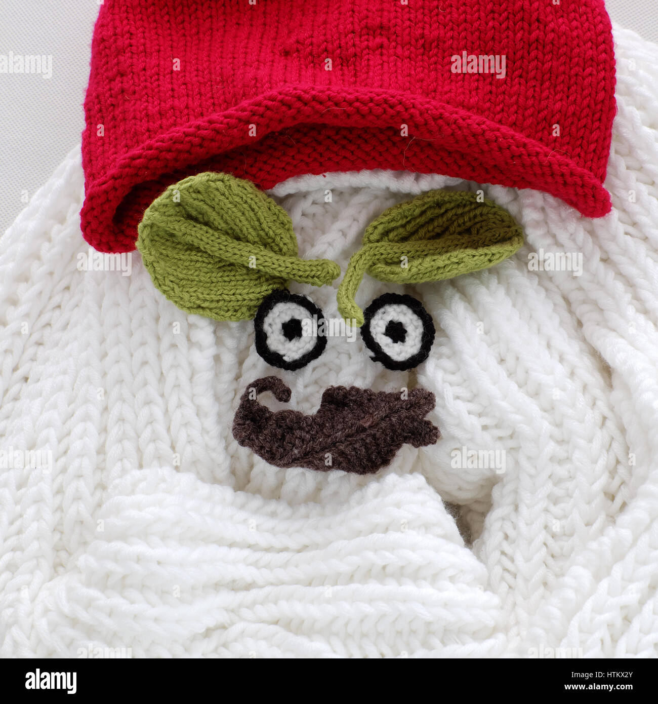 Humor-Augen des Winters von Garn, diy einfachen Hintergrund für Xmas Urlaub durch gestrickte Blatt für Augenbrauen, Nase auf weißen Schal Hintergrund, lustiges Gesicht Handwerk Stockfoto