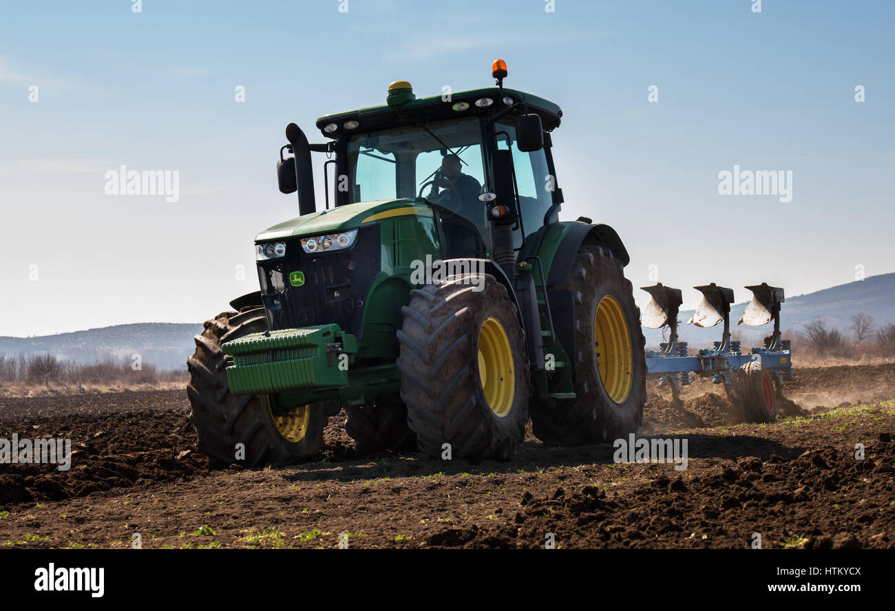 Varna, Bulgarien - 5. März 2017 pflügen ein Feld mit John Deere Traktor. John Deere wurde 1995-1999 hergestellt und es hat JD 7,6 L oder 8,1 L 6-Zyl d Stockfoto