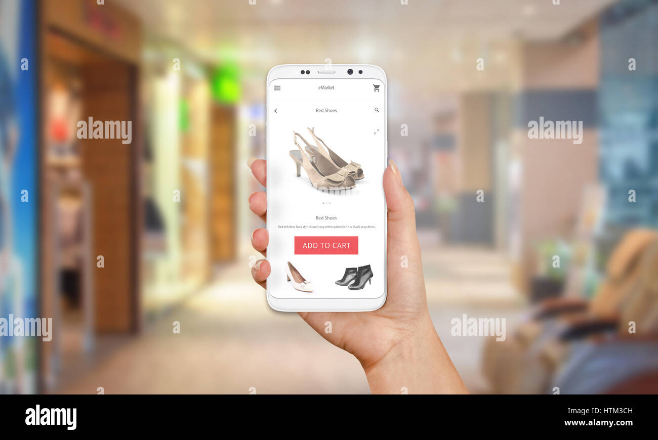 Online-Shop auf dem Handy-Display. Moderne weiße Smartphone mit runden Kanten in Mädchen Hand. Einkaufszentrum im Hintergrund. Stockfoto