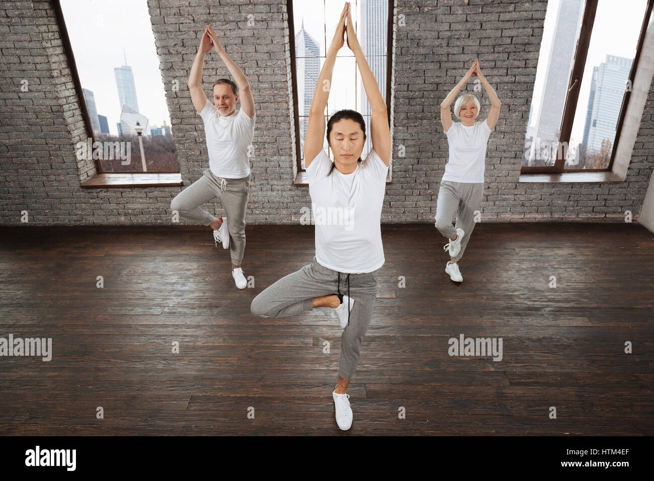 Yoga-Lehrer, die Hände über dem Kopf zusammenzuhalten Stockfoto