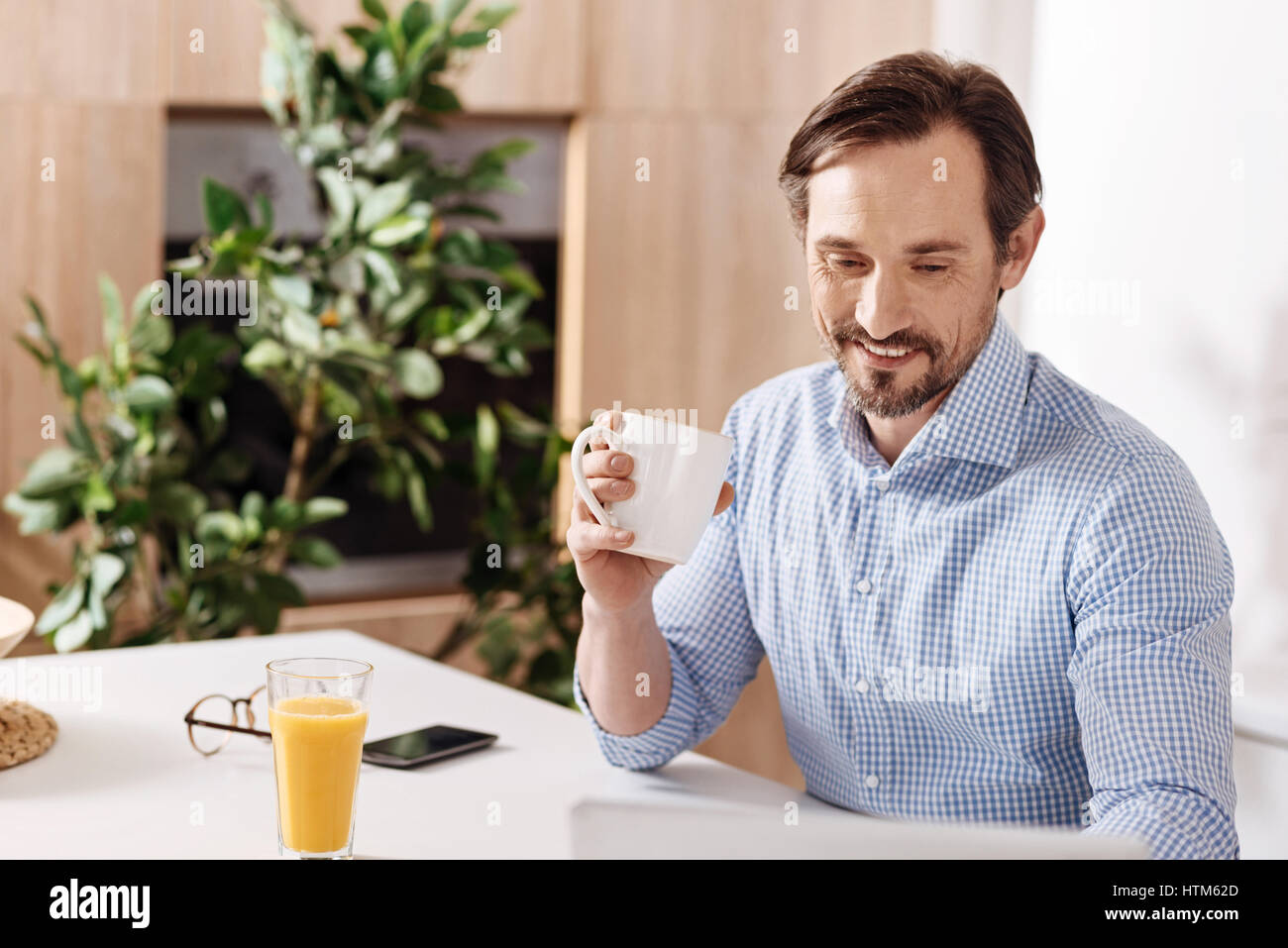 Freudige selbständige Mann frühstücken zu Hause Stockfoto