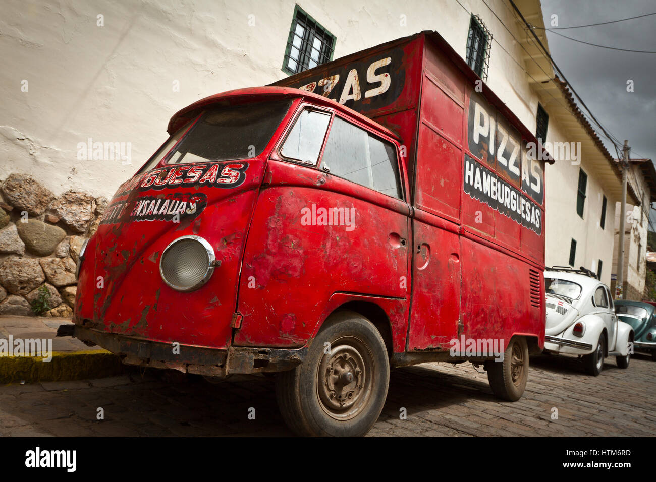 Alte Vintage rot Pizzawagen in Cuzco, Peru in den Anden in einer gepflasterten Straße vor dem städtischen Gebäude geparkt Stockfoto