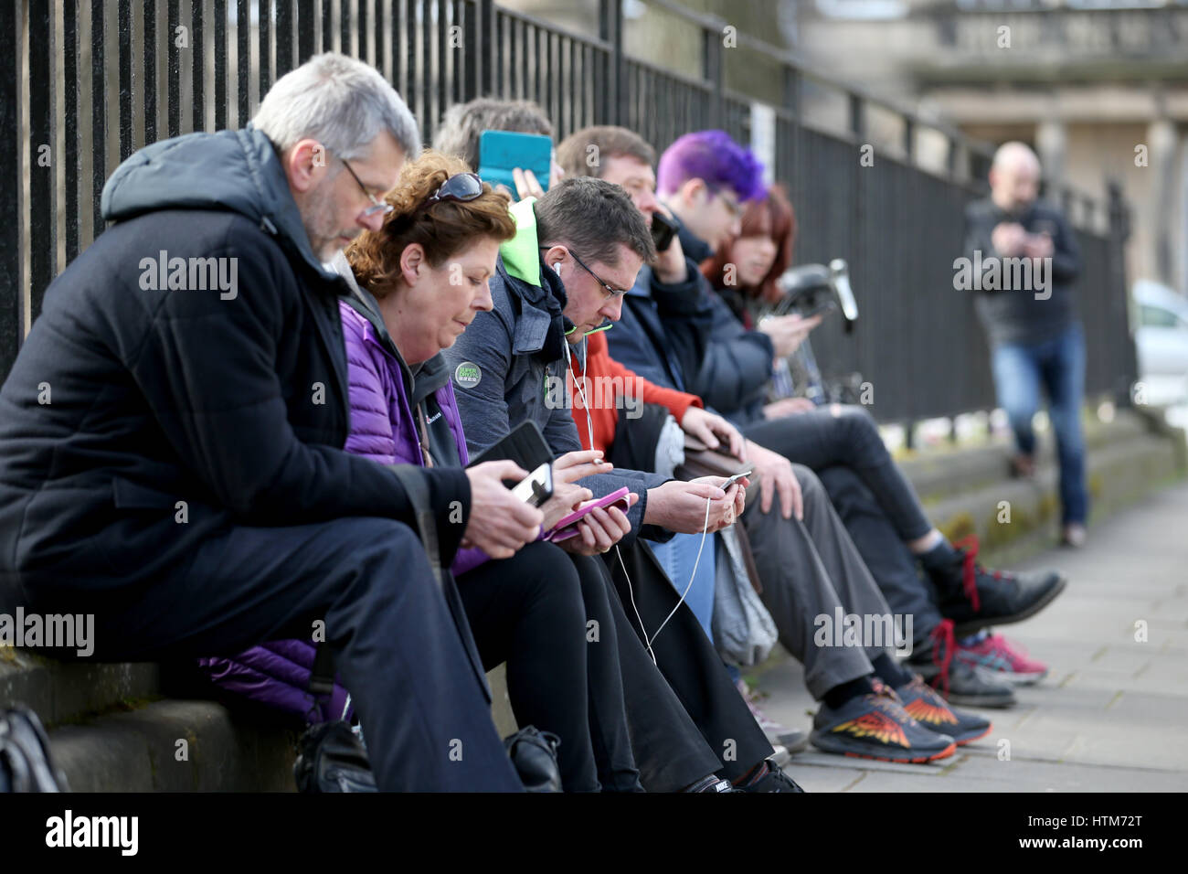 Mitglieder der Öffentlichkeit und hören und beobachten auf Smartphones ein Live-Stream von First Minister Nicola Sturgeon bei einer Pressekonferenz, in Charlotte Square, Edinburgh, wo sie sagte, sie wird den Schotten eine "echte Wahl" zwischen Brexit und dem Austritt aus dem Vereinigten Königreich in einer zweiten Abstimmung über die Unabhängigkeit. Stockfoto