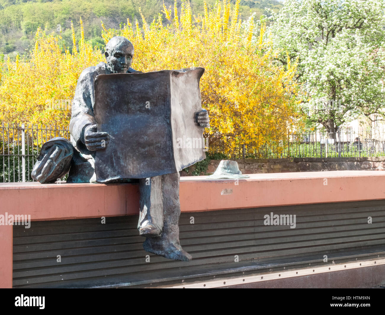 Neustadt ein der Weinstraße, Deutschland - 19. April 2015: Statue eines Mannes Lesen einer Zeitung im Schatten eines Baumes im Park der Stadt Stockfoto