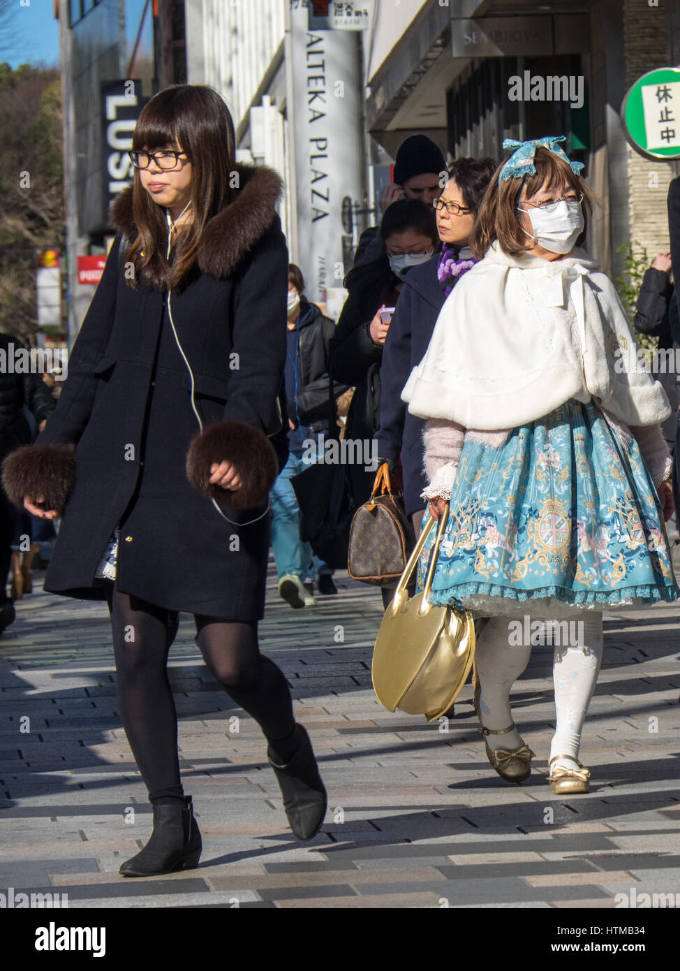 Zwei junge Japanerinnen zu Fuß entlang einer shopping Straße InJingumae Shibuya, Tokyo, Japan. Stockfoto