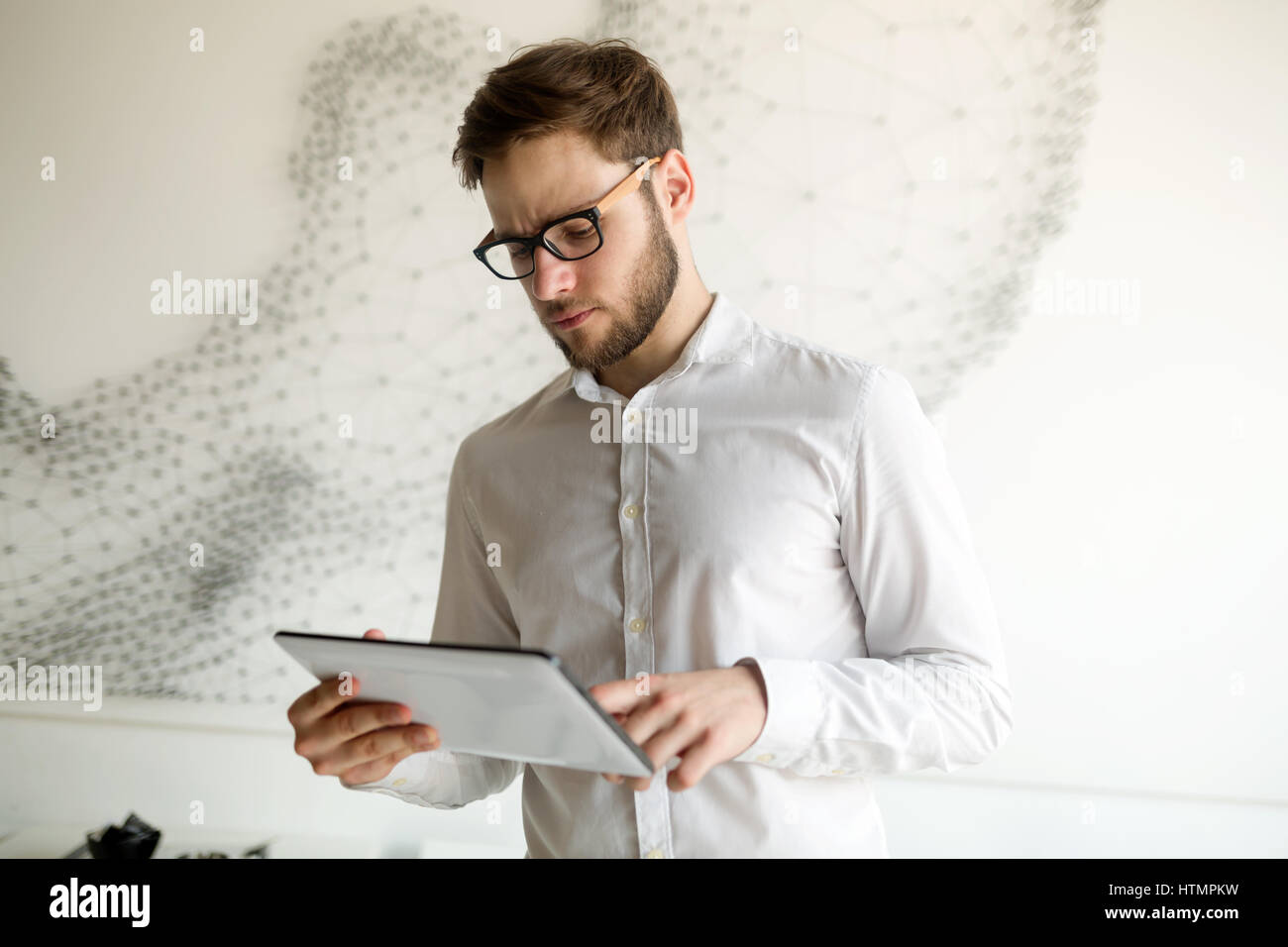 Hübscher Kerl in Hemd und Brille mit tablet Stockfoto