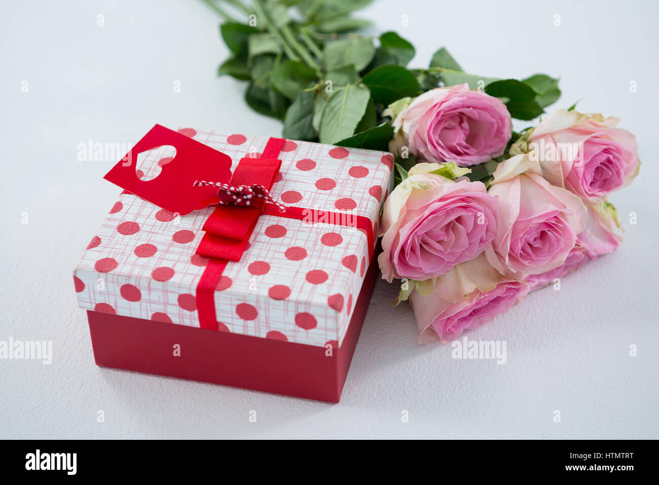 Nahaufnahme der Geschenk-Box mit Haufen von Rose auf weißem Hintergrund Stockfoto