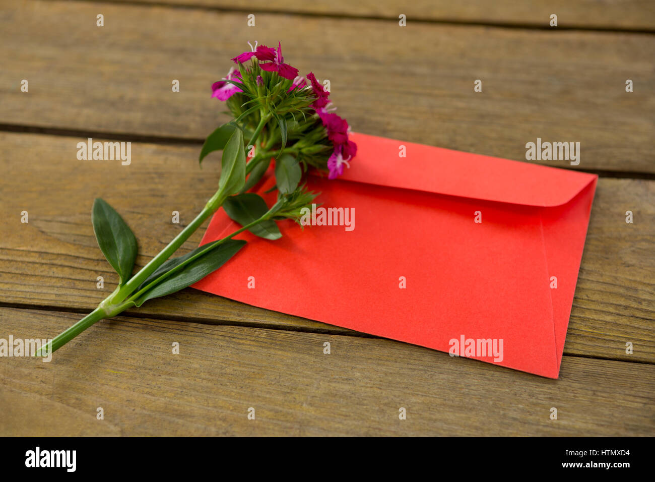 Rosa Blumenstrauß mit Umschlag auf Holzbrett Stockfoto