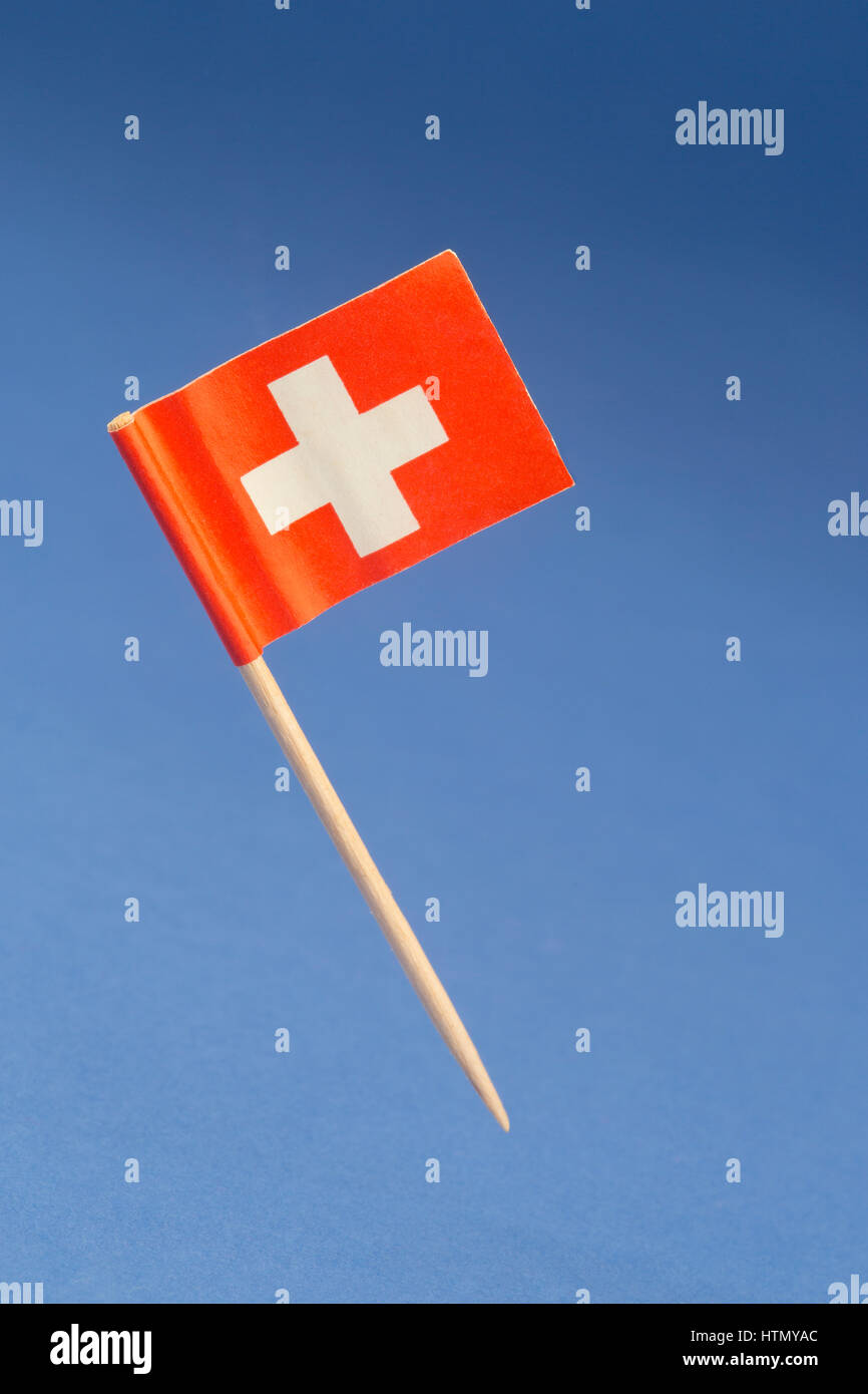 Papier Fahne der Schweiz auf blauem Hintergrund Stockfoto