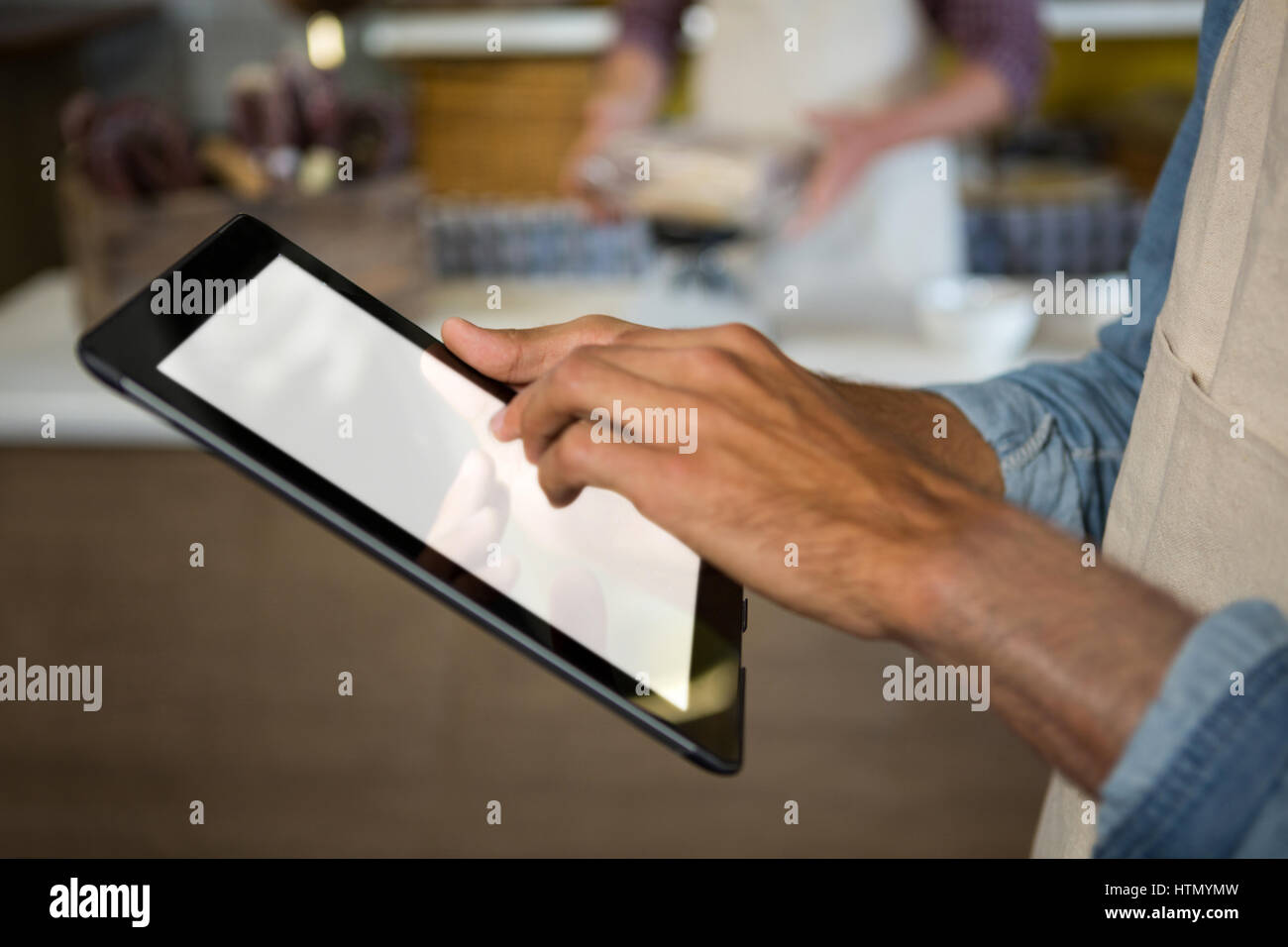Mittleren Bereich der männlichen Angestellten mit digital-Tablette in der Nähe von Fleischtheke im Markt Stockfoto