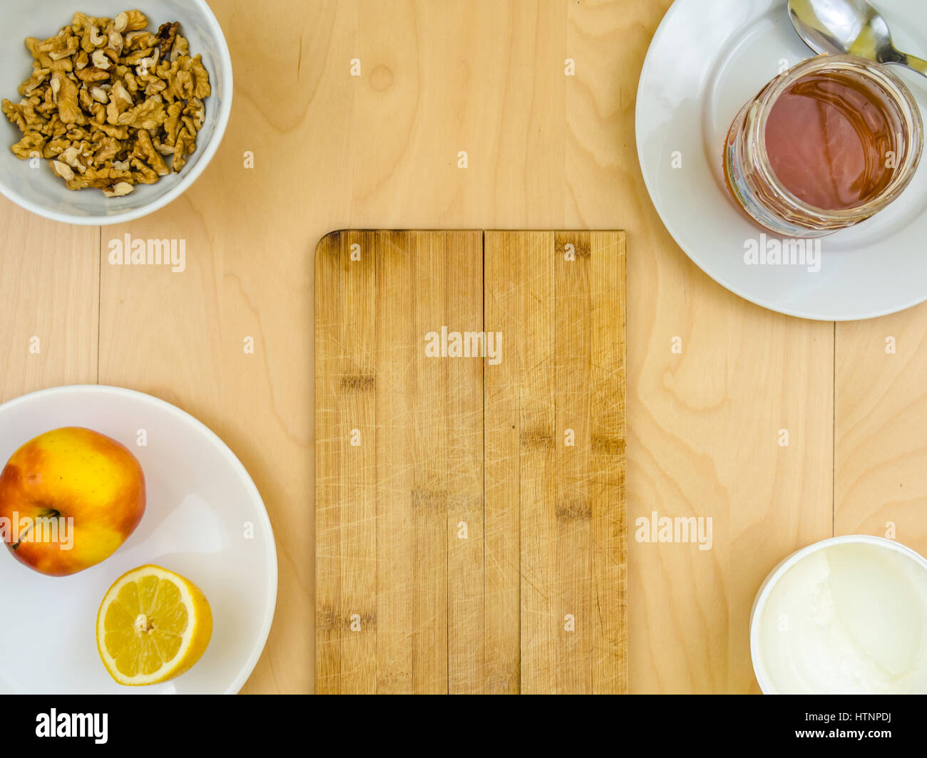 Vier Zutaten für ein gesundes und nahrhaftes Snack oder Smoothie, Apfel Zitrone Obst, Quark, Honig, Nüssen Walnüsse, auf Platten von Top V geschält Stockfoto