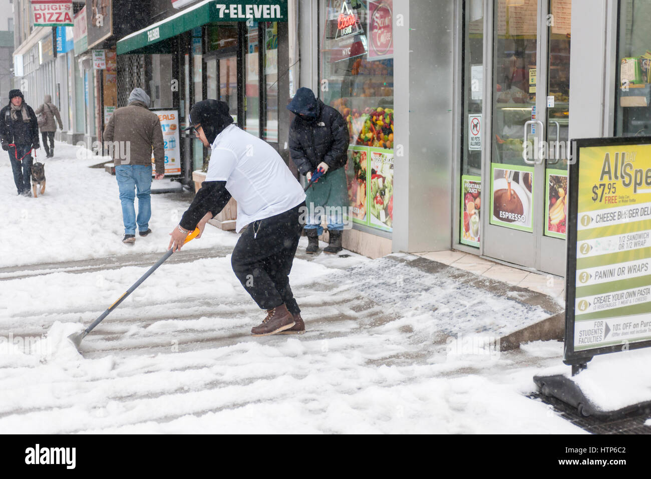 New York, USA. 14. März 2017. Arbeiter Schaufeln Schnee im Stadtteil Chelsea in New York auf Dienstag, 14. März 2017. Ursprünglich vorhergesagt wie ein Schneesturm mit bis zu 20 Zoll Schnee Sturm seinen Kurs geändert hat und nur 4 bis 6 Zoll von Regen, Schneeregen und Schnee zu erwarten sind, natürlich begleitet von heulenden Winde. (© Richard B. Levine) Bildnachweis: Richard Levine/Alamy Live-Nachrichten Stockfoto