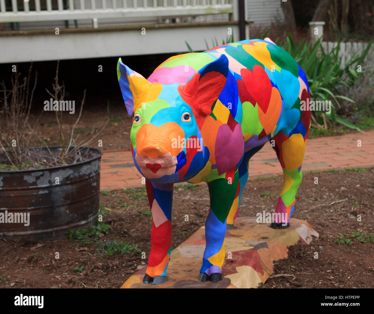 künstlerische Schwein-Statue mit gemalten Herzen Stockfoto