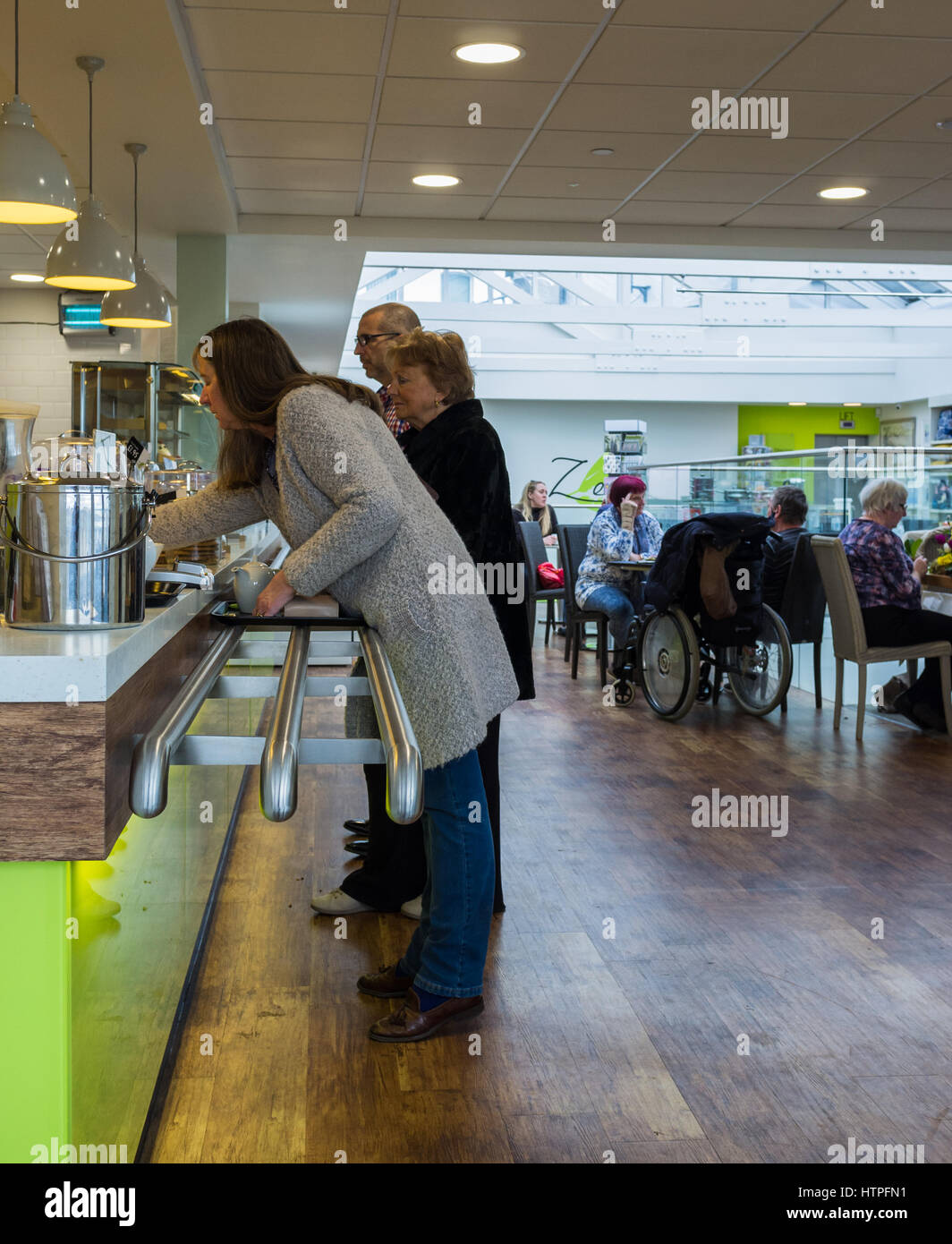 Frau an der Theke, Kaffee und Kuchen in einem Torquay-Restaurant-Café zu kaufen. Stockfoto