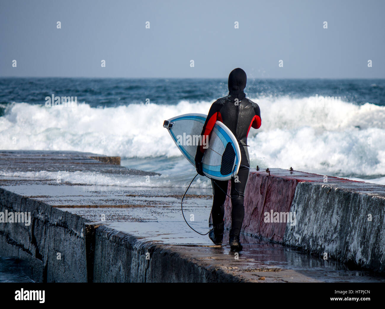 Surfer geht ins Wasser tragen einen Neoprenanzug im Winter. Kalt, Surfen.  Wave Splash. wasserdichten Anzug Stockfotografie - Alamy