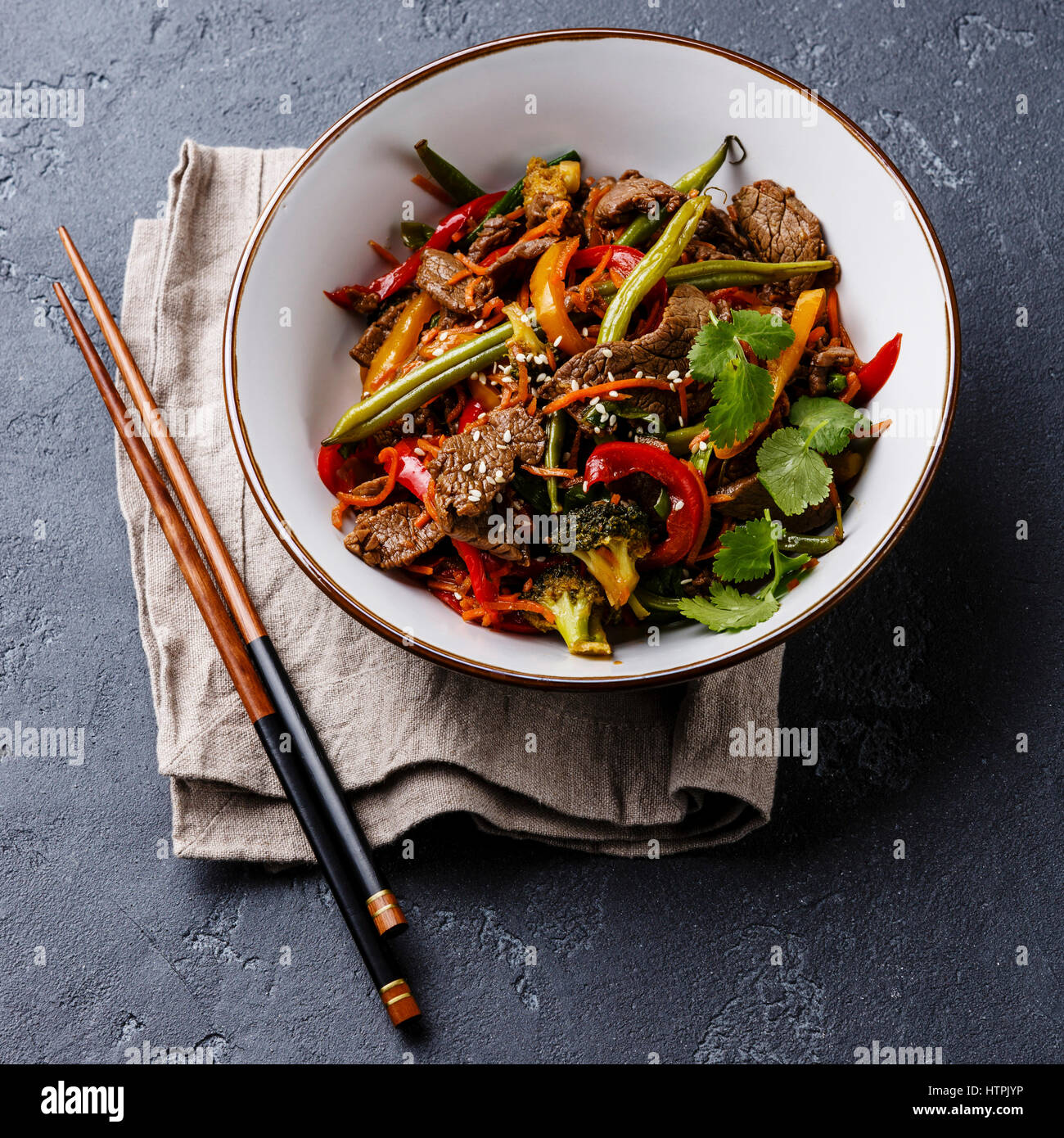Szechuan Rindfleisch unter Rühren braten mit Gemüse in Schüssel auf dunklen Stein Hintergrund Stockfoto