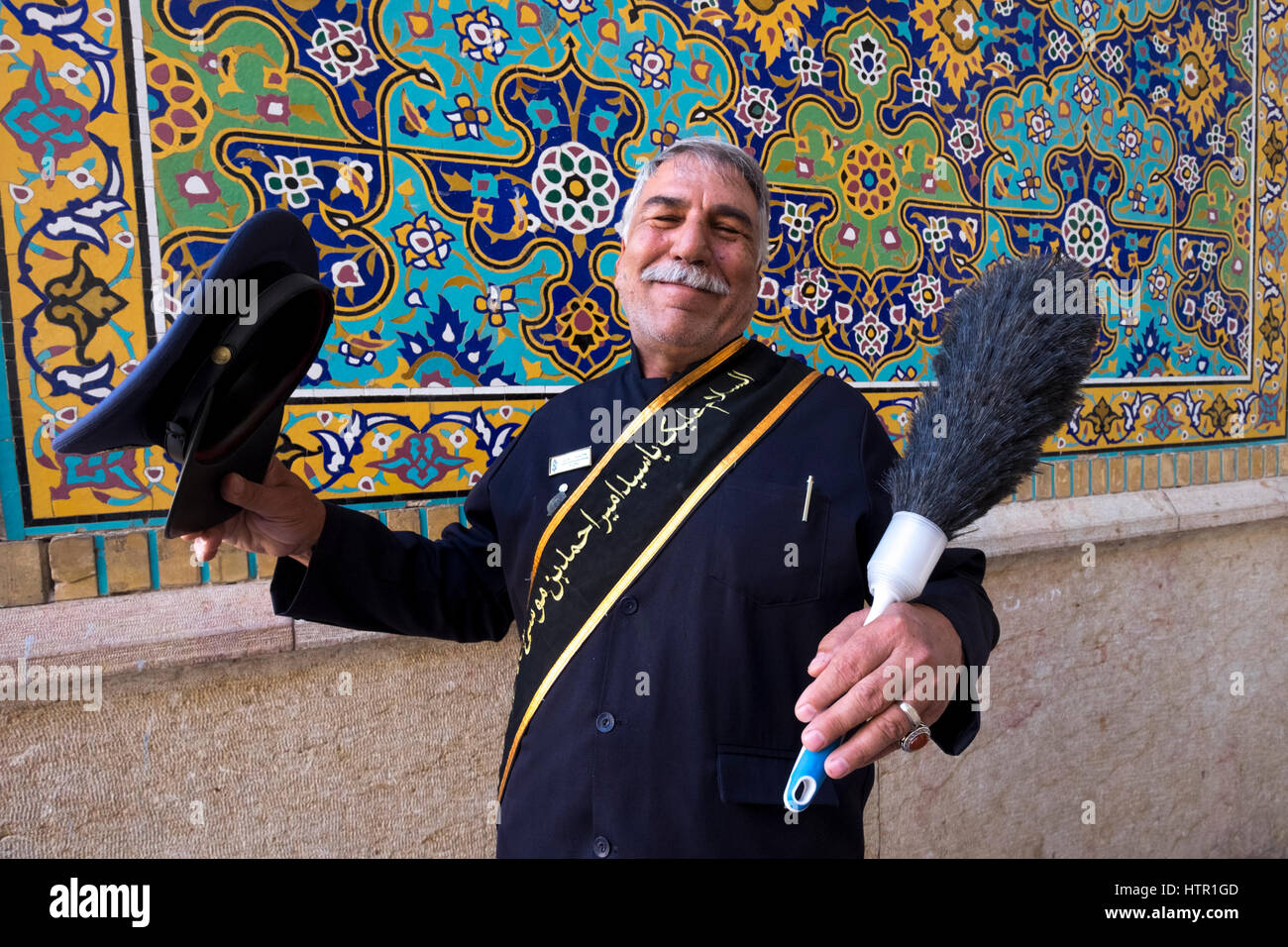 Eine religiöse Attendant entspannt mit einem Staubtuch am Eingang des Shah Cheragh Heiligtum in Shiraz, Provinz Fars, Iran Stockfoto