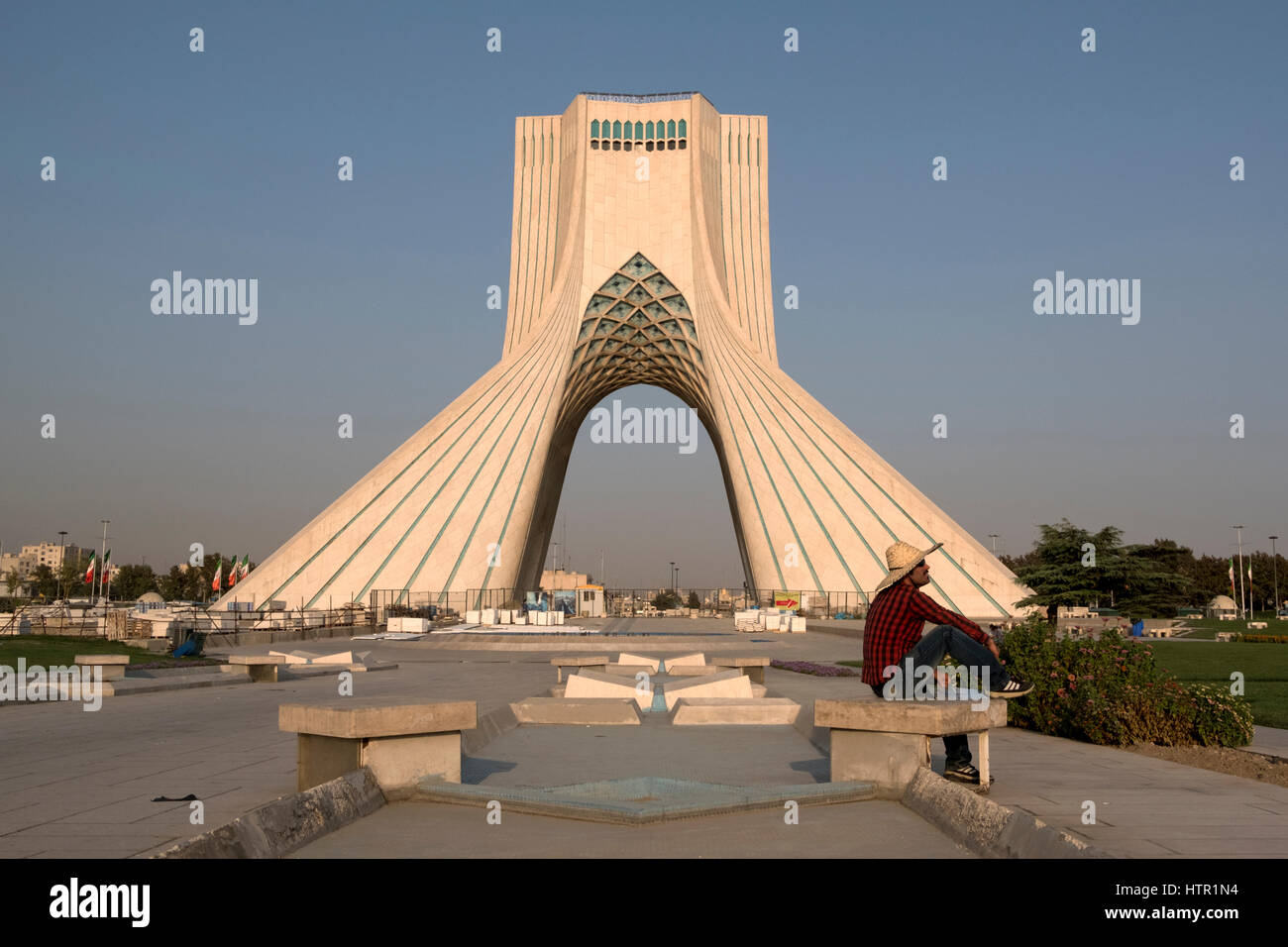 Ein Tourist sitzt vor der Azadi-Turm oder Freedom Tower in Azadi-Platz, Teheran, Iran Stockfoto