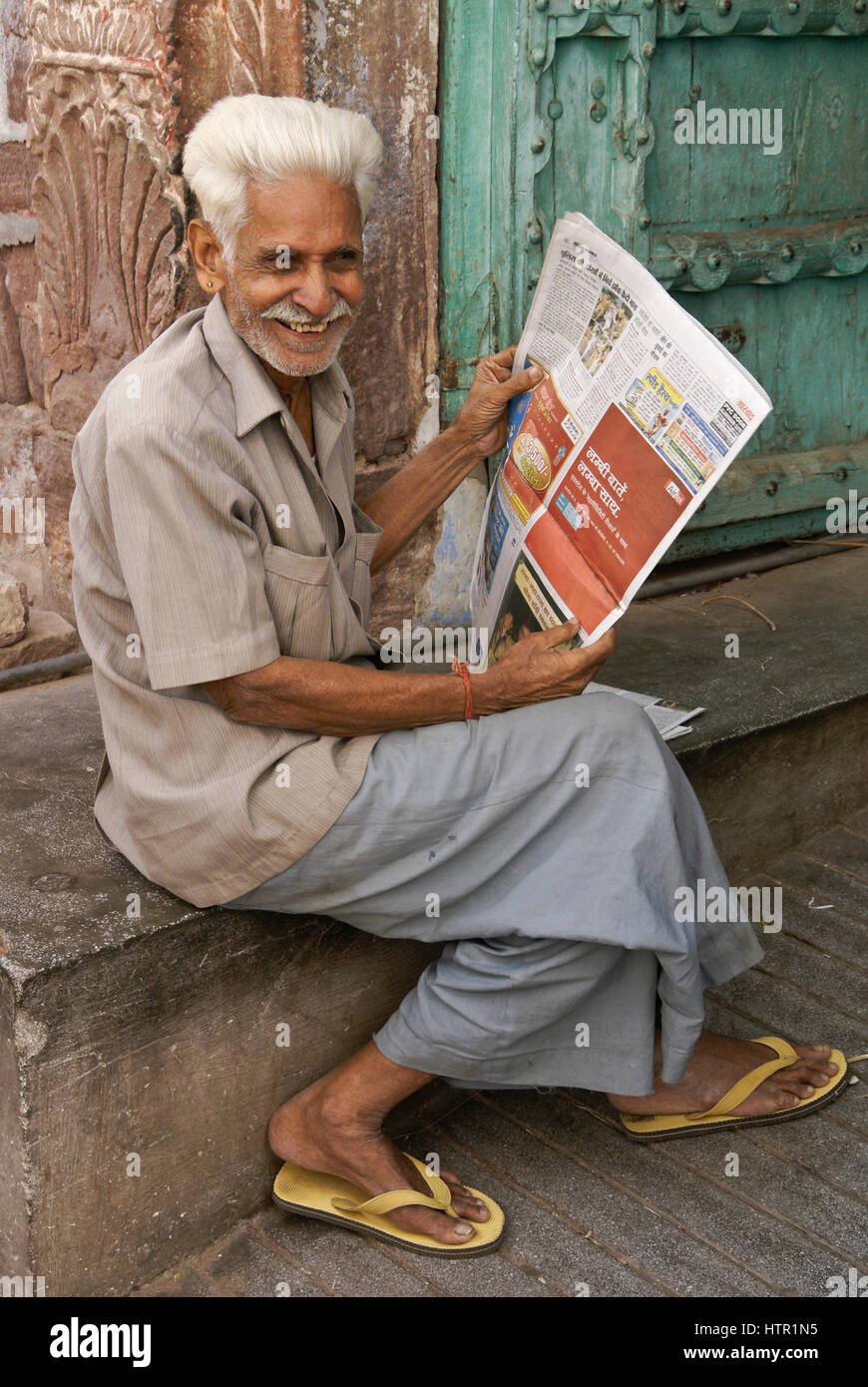 Ältere Mann lesen Zeitung vor seinem Haus, Jodhpur, Rajasthan, Indien Stockfoto