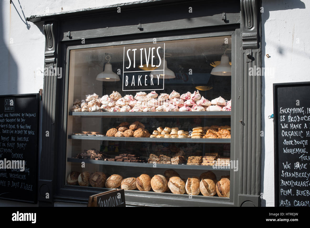 Eine Bäckerei Schaufenster voller Kuchen und frisches Brot bei St. Ives, Cornwall, England. Stockfoto