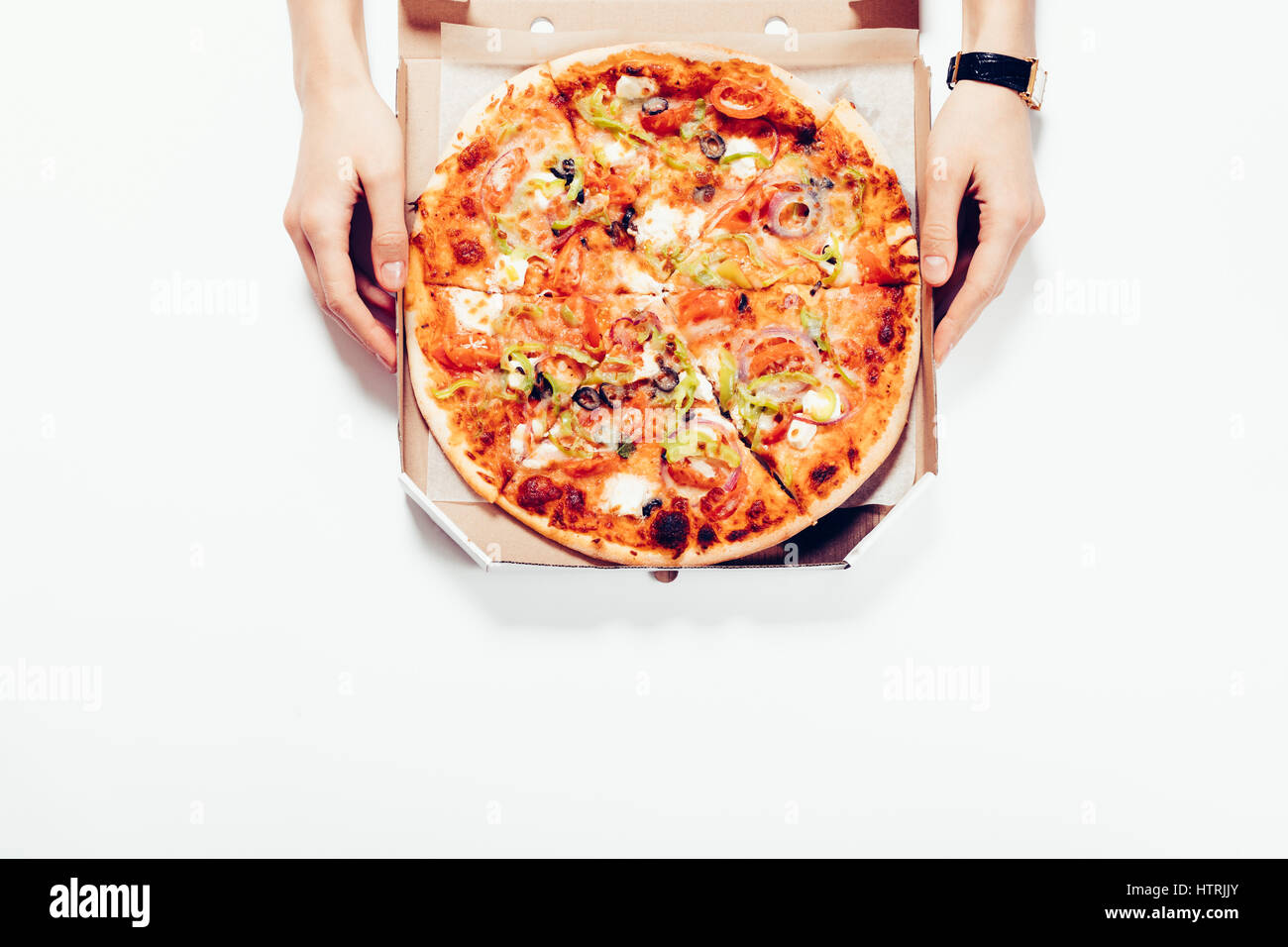 Weibliche Hände Pizza in einer Box auf einem weißen Tisch, Ansicht von oben Stockfoto