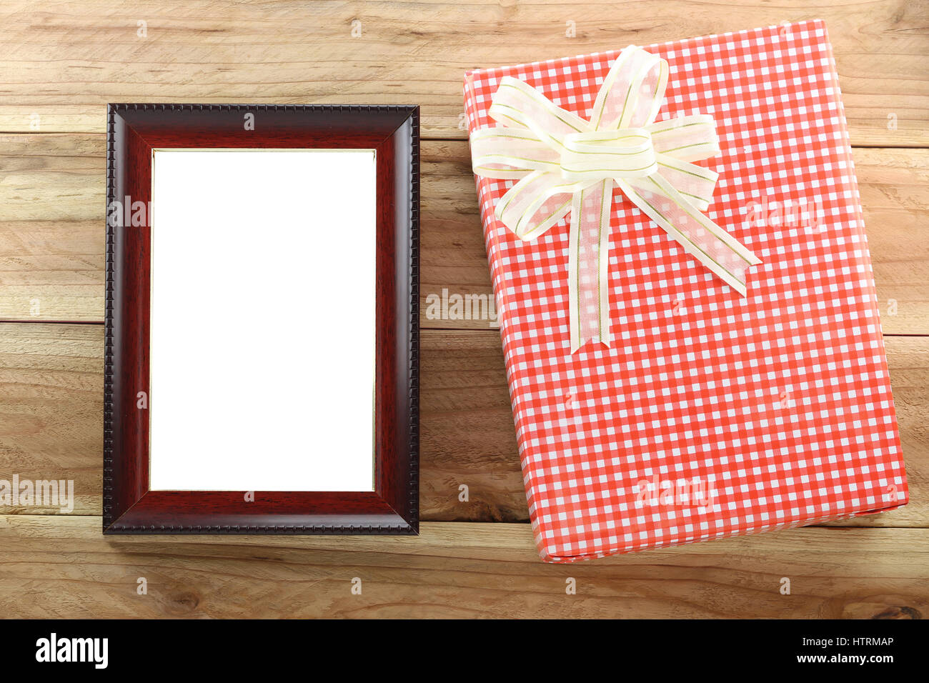 Roten Geschenkbox mit leeren Holz Bilderrahmen auf Holz Hintergrund, Konzept von Weihnachten und wichtiger Tag. Stockfoto