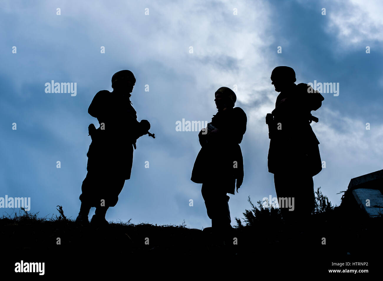 Deutsche Fallschirmjager Reenactor Silhouette gegen einen stürmischen Himmel während einer Schlacht Reenactment in Fort Camden, County Cork, Irland mit Textfreiraum. Stockfoto