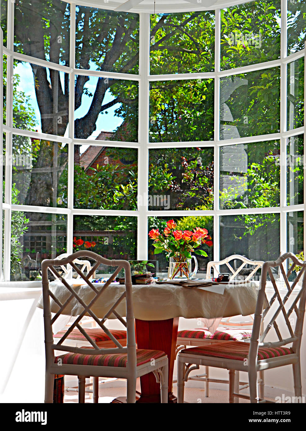 Erker mit Tisch und Stühlen mit Blick auf Garten. Stockfoto