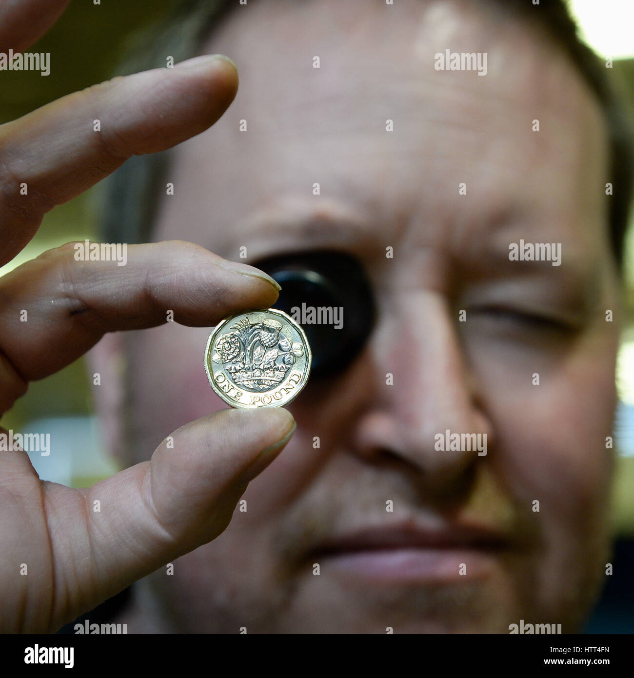 &ETH; KEINE KOMMERZIELLE NUTZUNG Royal Mint Circulating Coin Press Setter Hywel Price inspiziert eine 12-seitige 1-Pfund-Münze mit Augenglas, wie sie in der Royal Mint in Llantrisant, Wales, geprägt wird. Stockfoto